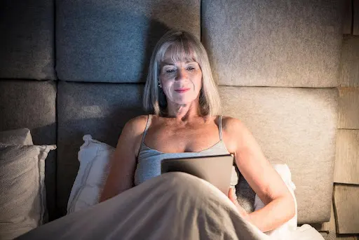 Woman Relaxing in Bed with Tablet