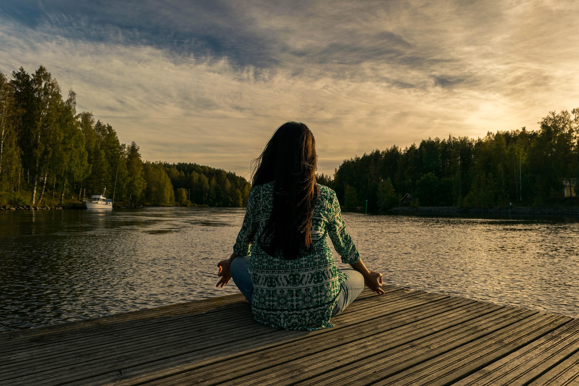 Woman meditating by a calm lake